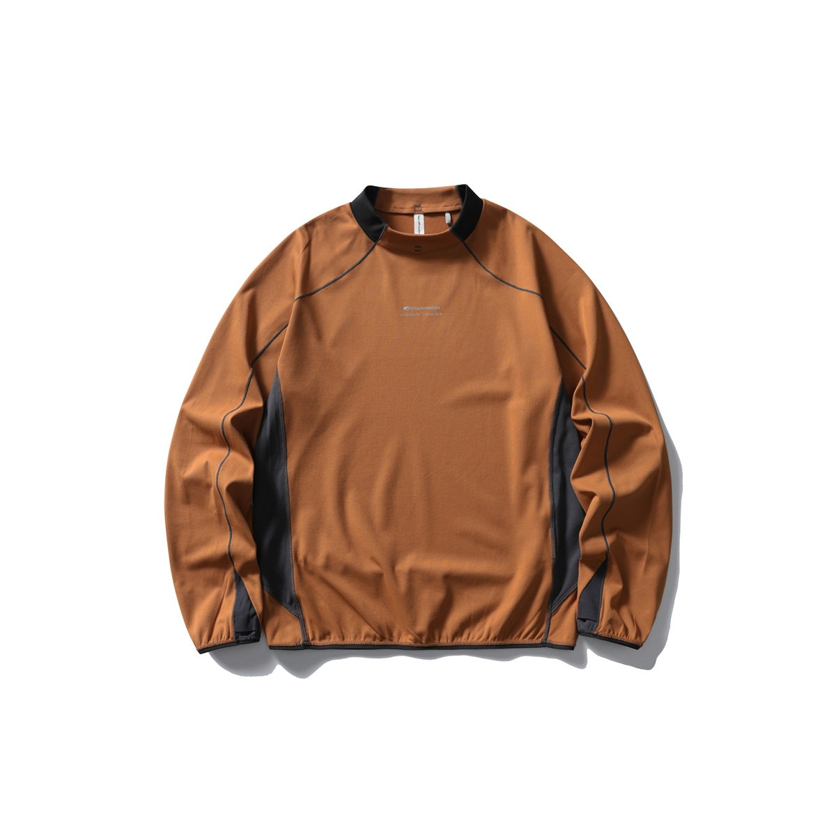 Rust orange long-sleeve mock neck top with black collar trim, dark gray side panels and contrast stitching, flat lay