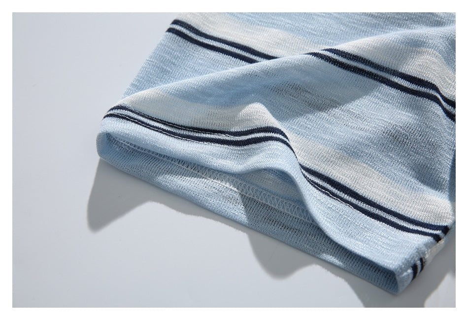 Close-up of a light blue and white striped knit garment hem with dark navy stripes and visible stitching.