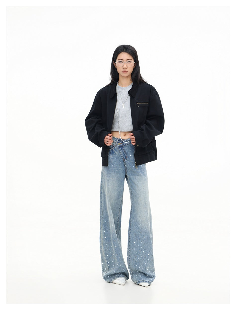 Full-length model wearing an open black oversized jacket with a zip chest pocket and wide-leg embellished jeans.