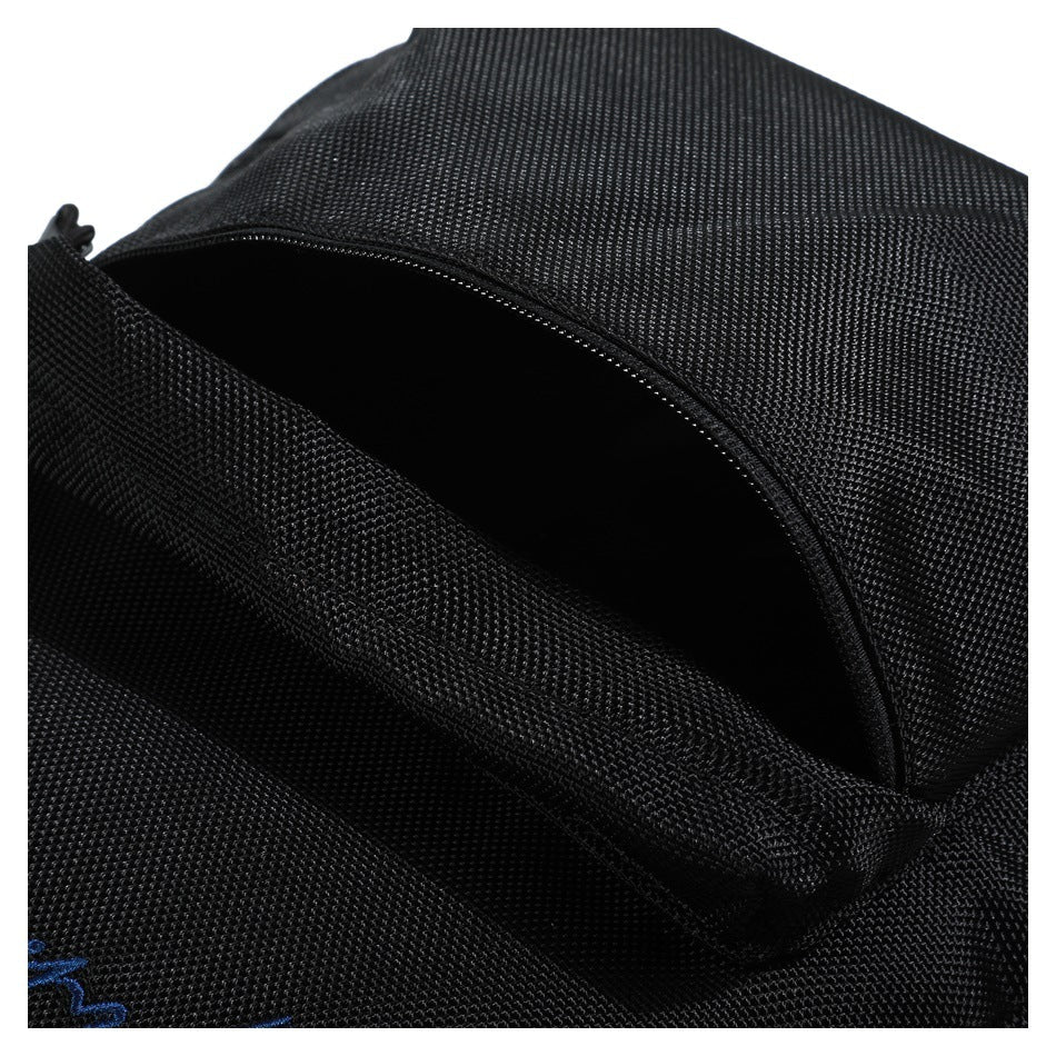 Close-up of an open zippered compartment on a black backpack.