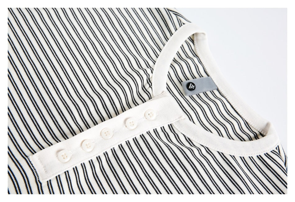 Close-up of a white-and-black striped shirt's white ribbed neckline and five-button placket.