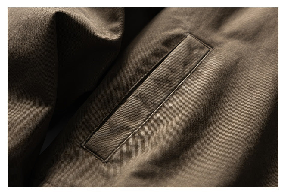 Close-up of a slanted welt pocket on a brown jacket.