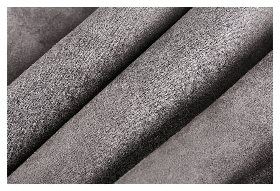 Close-up of gray fabric arranged in soft folds, showing its fine surface texture.