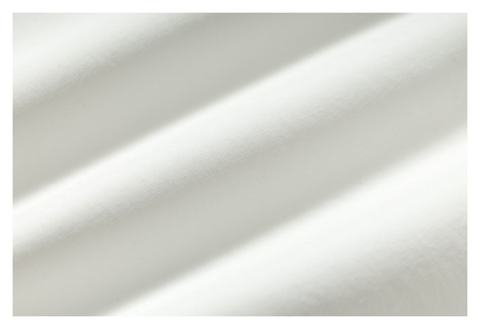 Macro view of the smooth, lightly textured off-white garment fabric.