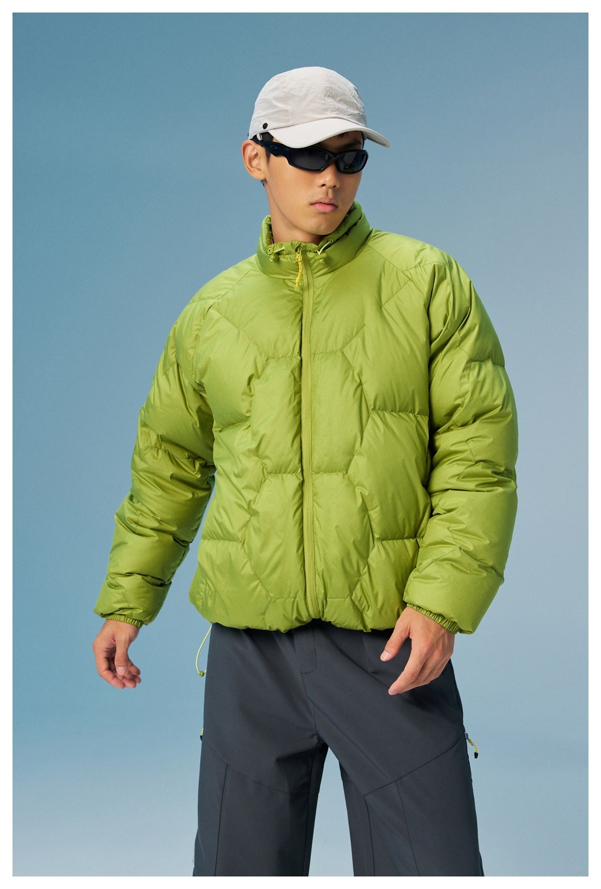 Model wearing a lime-green quilted zip-up jacket with a high drawcord collar, shown from the front.