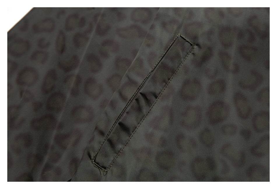 Close-up of a narrow stitched pocket on the charcoal jacket's subtly patterned fabric.