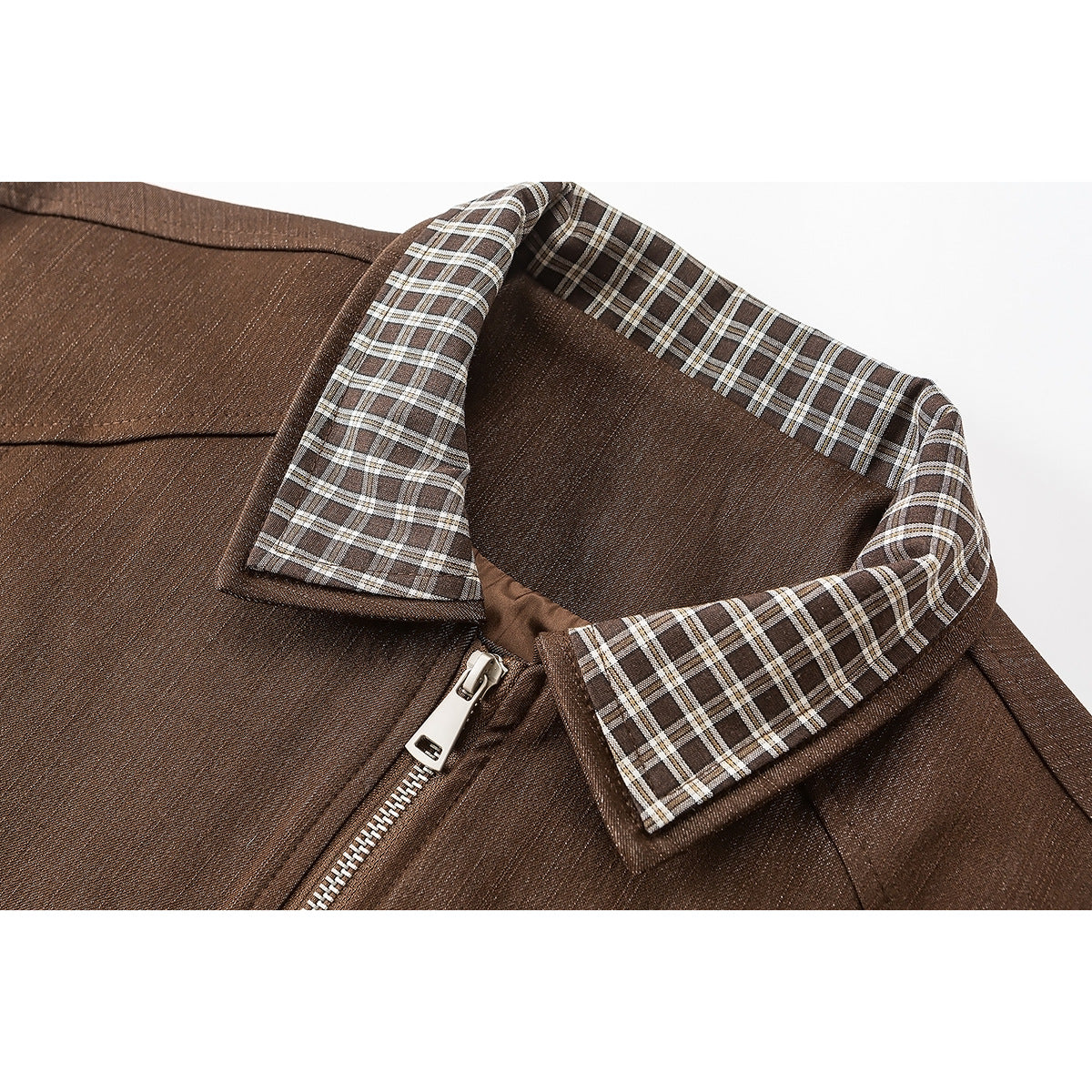 Close-up of a brown jacket's pointed plaid collar, inner facing, and silver front zipper.
