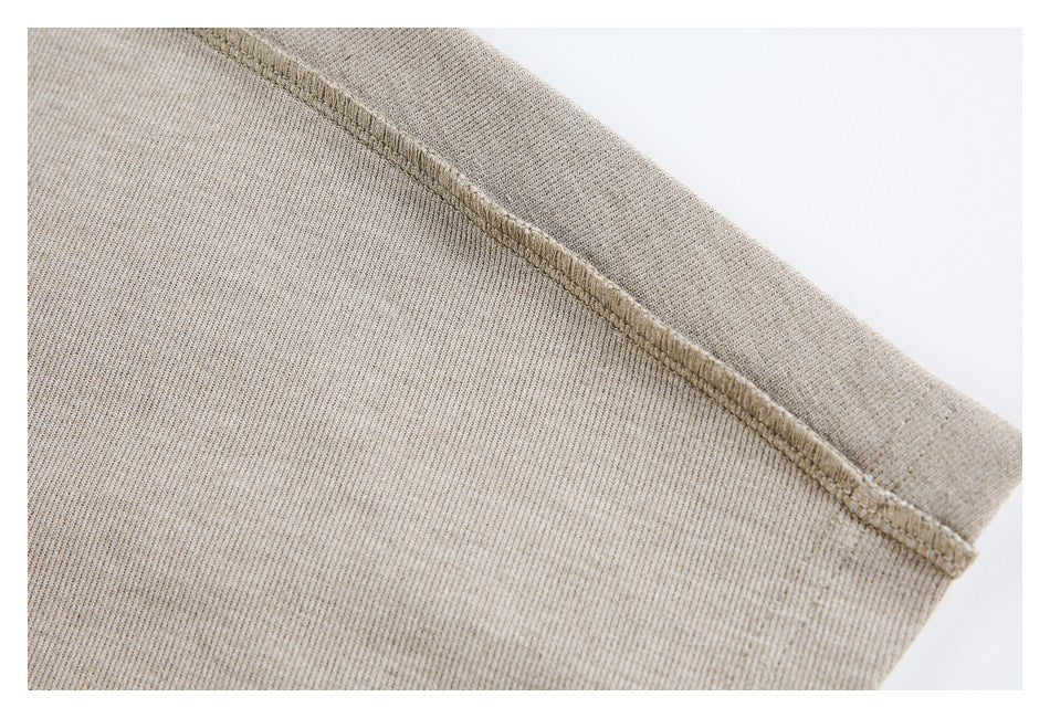 Close-up of a taupe knit garment seam with visible overlock stitching.