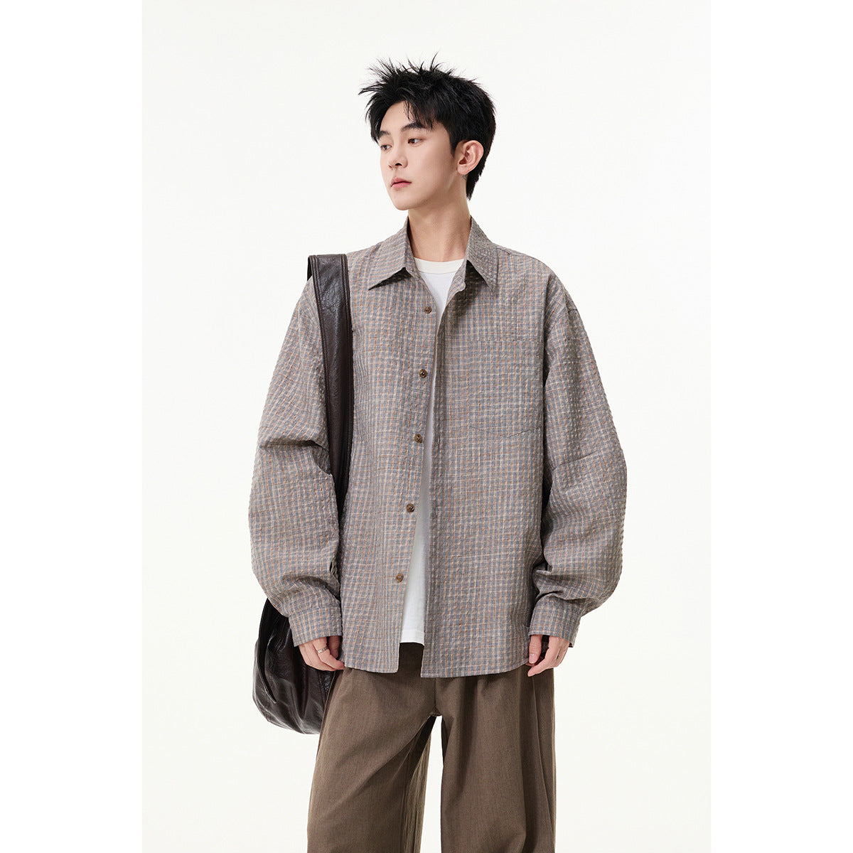 Model wearing a loose gray shirt with a fine blue-and-tan check, button front, and chest pocket.
