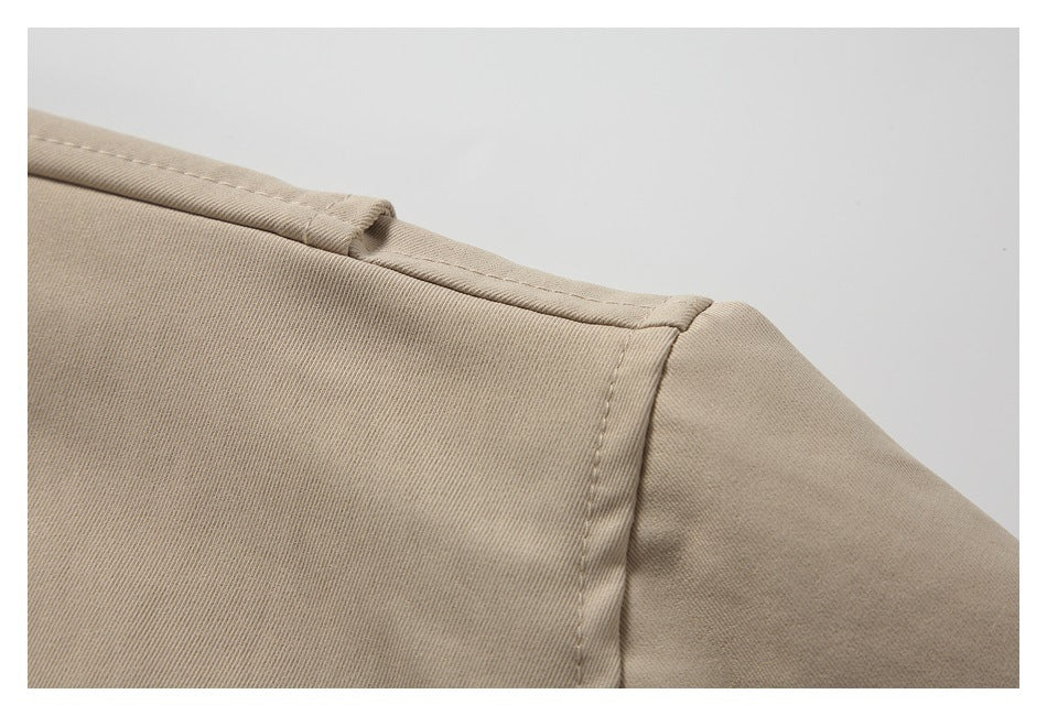 Close-up of the beige jacket's shoulder seam and stitching.