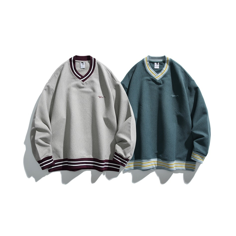 Two V-neck sweatshirts displayed side by side: light gray with burgundy trim and blue-green with yellow and white trim.