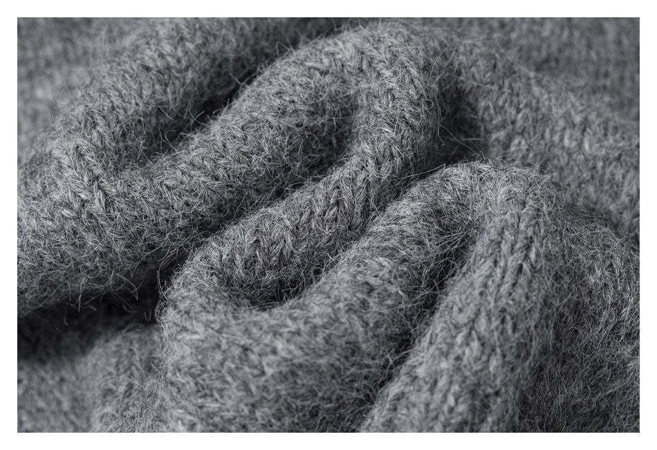 Extreme close-up of the gray garment’s fuzzy, textured knit stitches.