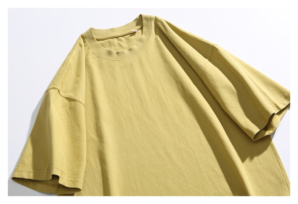 Close-up of a pale yellow T-shirt showing its crew neck, short sleeves, and upper chest.