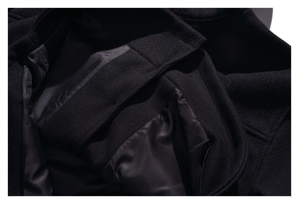 Close-up of the black coat opened to show its smooth dark lining and interior seams.