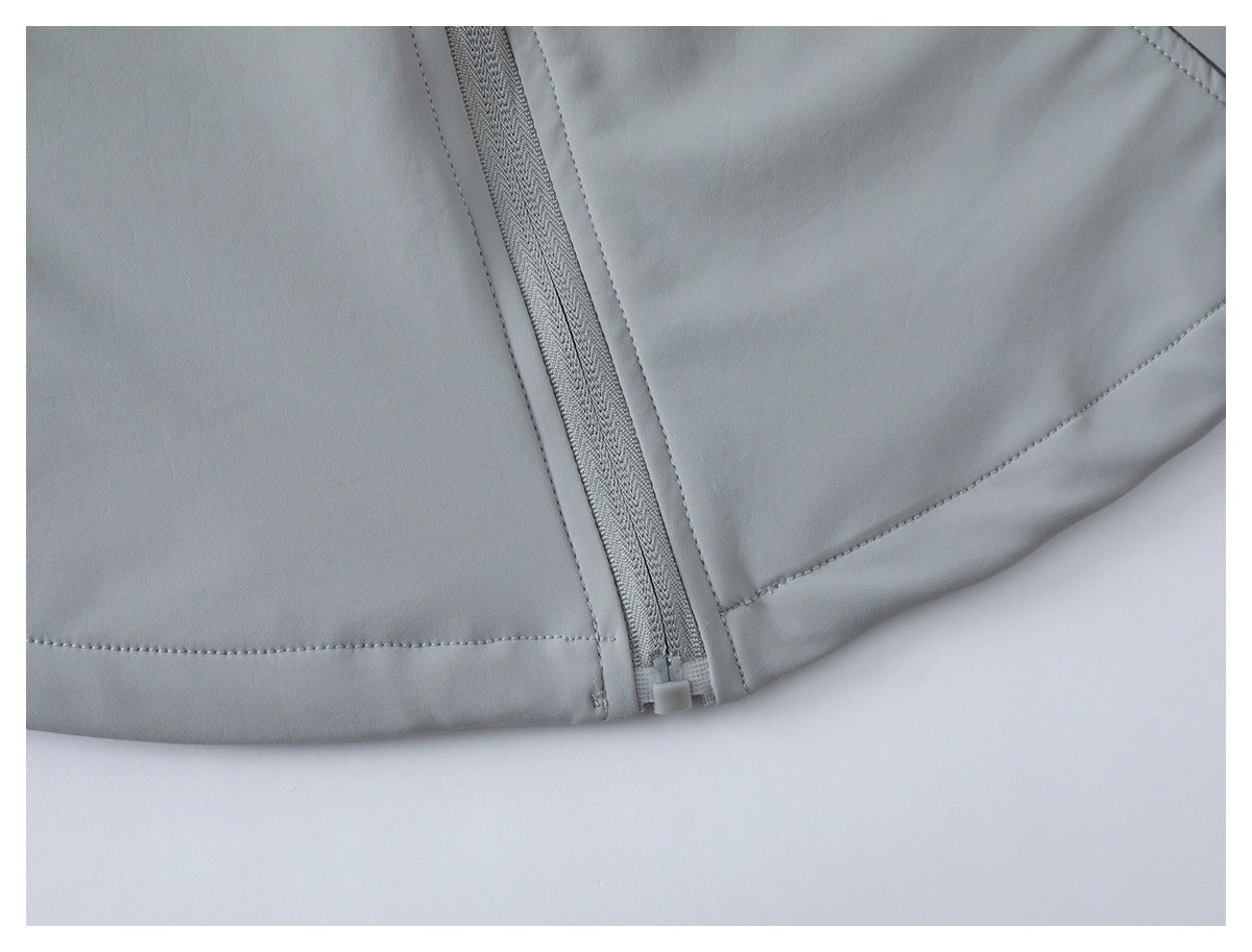 Close-up of a light gray garment hem with a zipper and stitched panel seams.