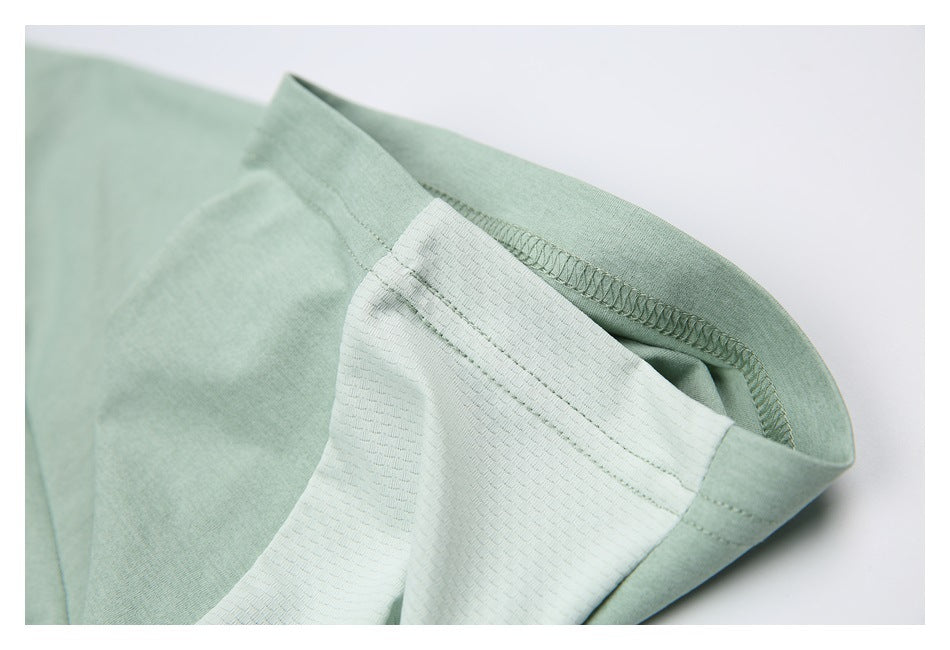 Close-up of a pale sage-green shirt sleeve, highlighting the lighter textured panel and stitched seam.