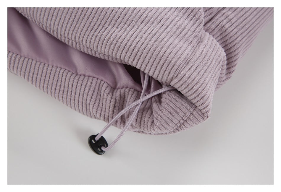 Close-up of the lilac jacket's hem drawcord and black cord lock.