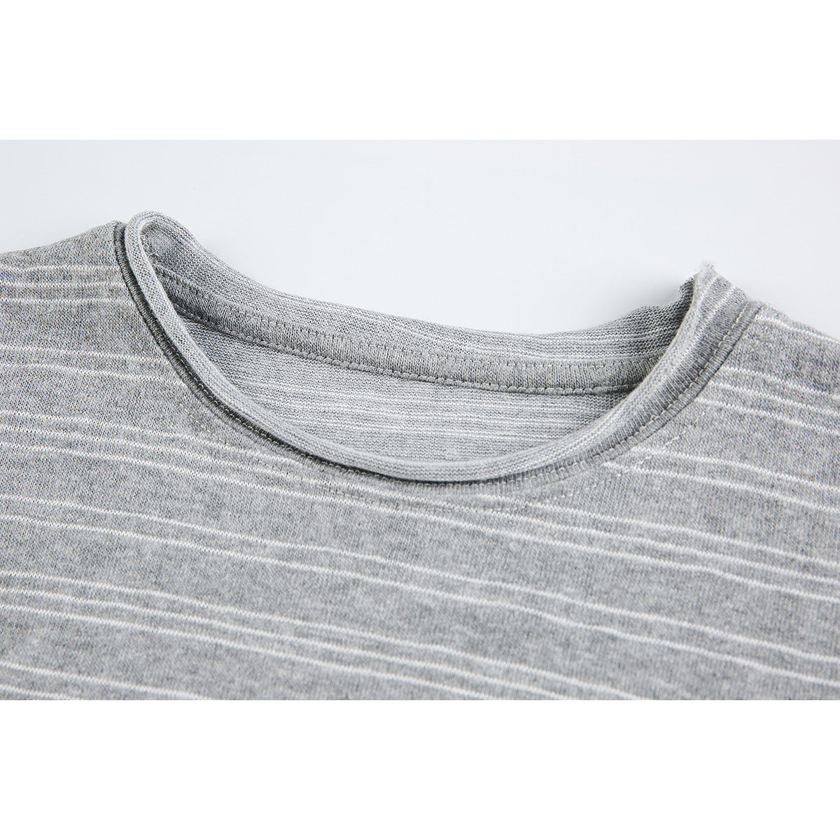 Close-up of the round neckline and thin white stripes on a heather gray top.