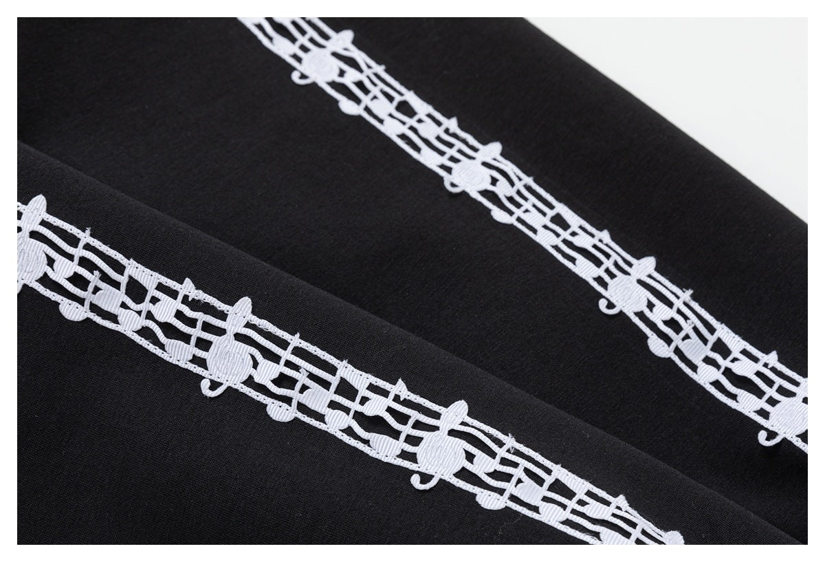 Close-up of black fabric with a white openwork decorative band running diagonally across it.