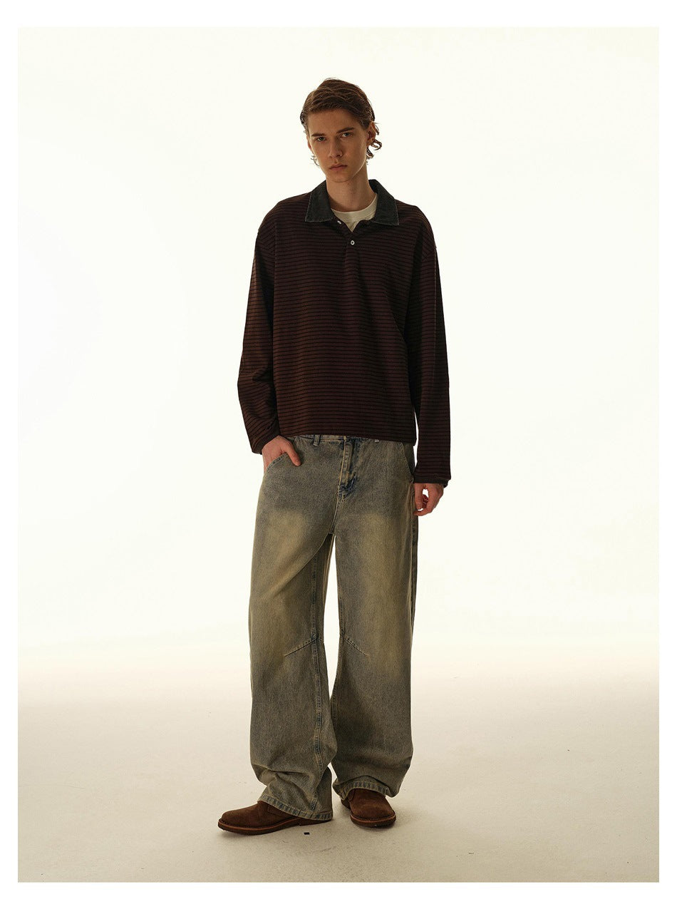 Model wearing a dark burgundy and black striped long-sleeve polo with a contrasting collar and wide-leg faded jeans.