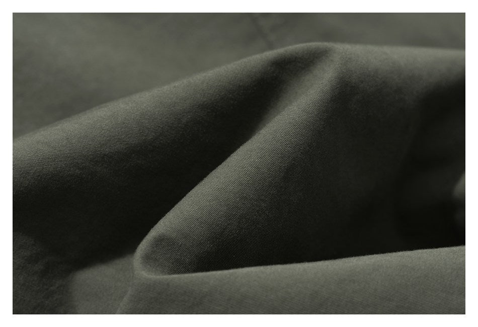 Macro view of dark olive fabric draped into folds, showing its fine surface weave.