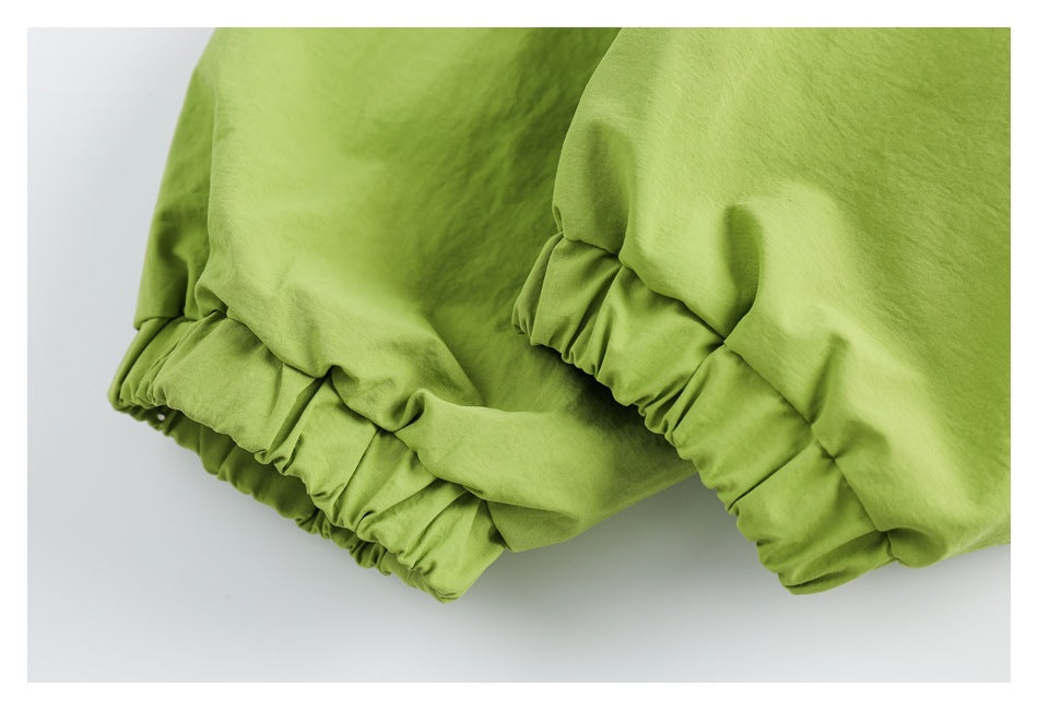 Close-up of gathered elastic cuffs on lime-green jacket sleeves.