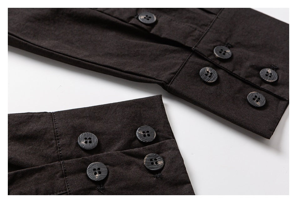 Close-up of a dark garment with several black four-hole buttons on overlapping button plackets.