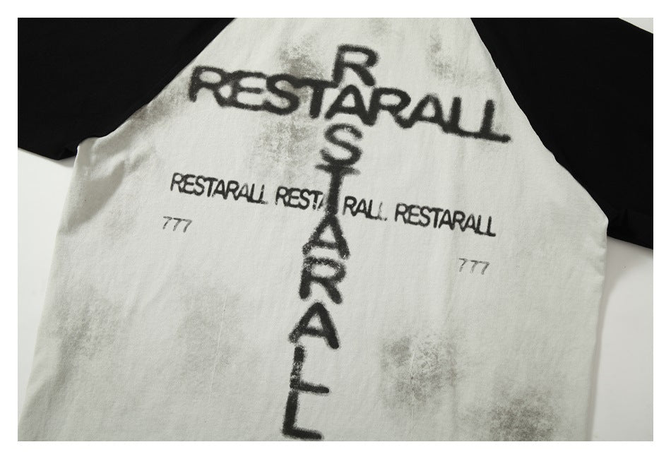Close-up of a white shirt body with black raglan sleeves and repeated black English lettering.