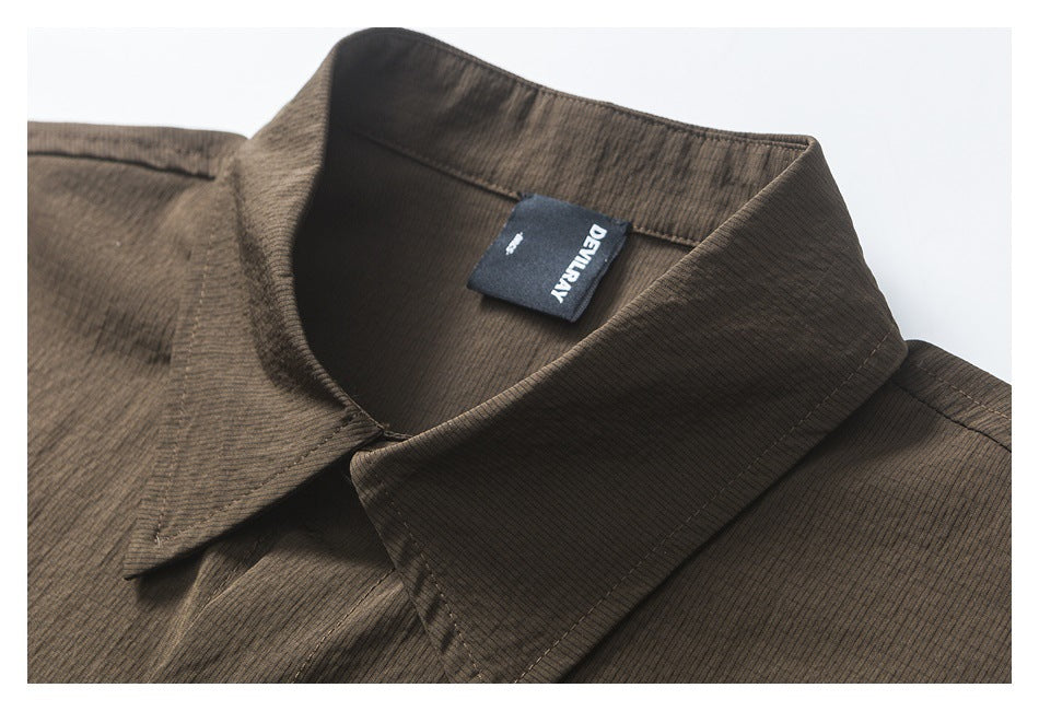 Close-up of the dark brown striped shirt collar and its sewn-in black label.