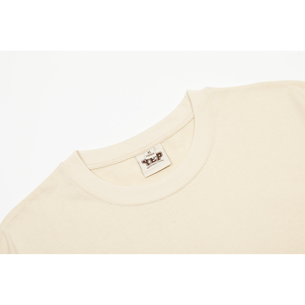 Close-up of the cream T-shirt's ribbed crew neck and sewn-in size label.