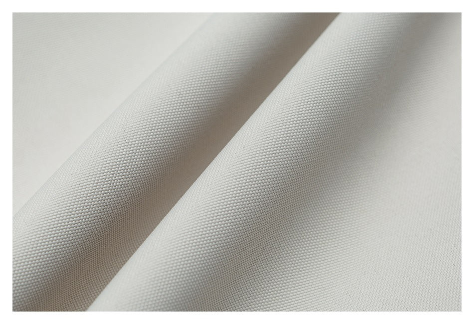 Close-up of off-white fabric with a fine woven texture and a raised diagonal fold.