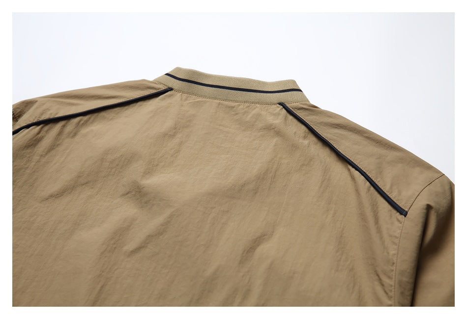 Close-up of the tan jacket's back shoulder, showing dark piping and a striped ribbed collar.