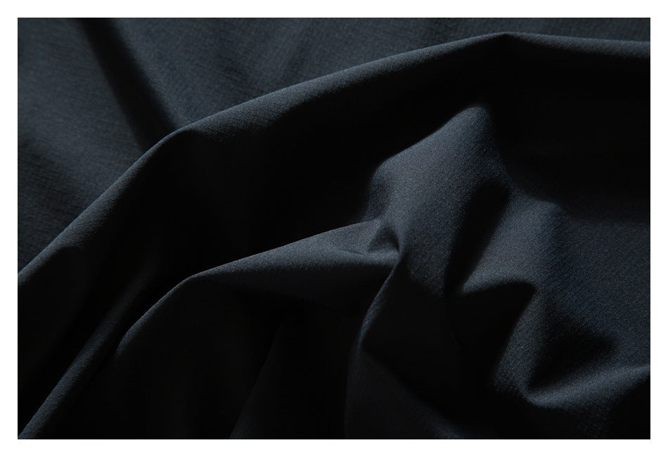 Close-up of black fabric arranged in folds, showing its smooth surface and drape.