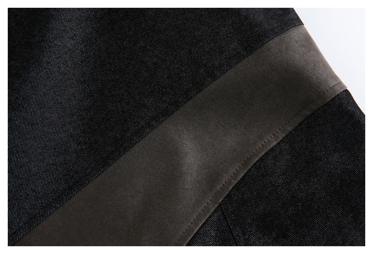 Close-up of a wide dark fabric band crossing black garment fabric.