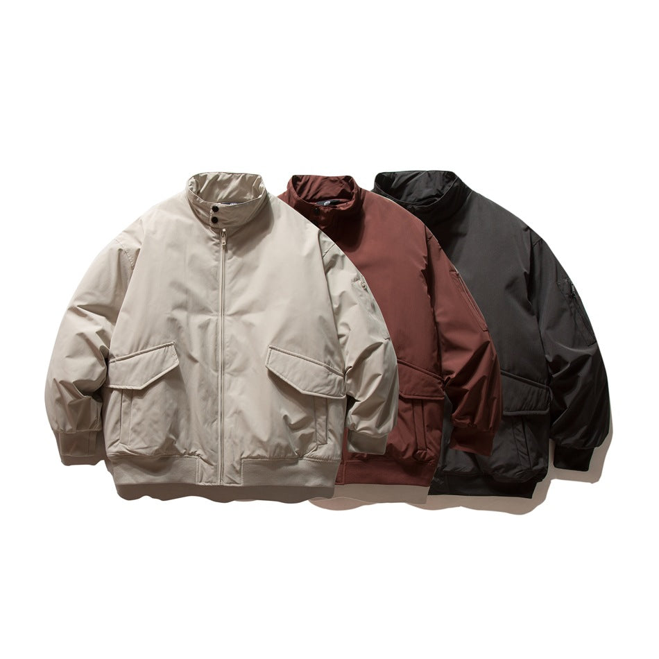 Three front-view jackets with stand collars, zip closures, flap pockets, and ribbed trim in beige, rust, and black.