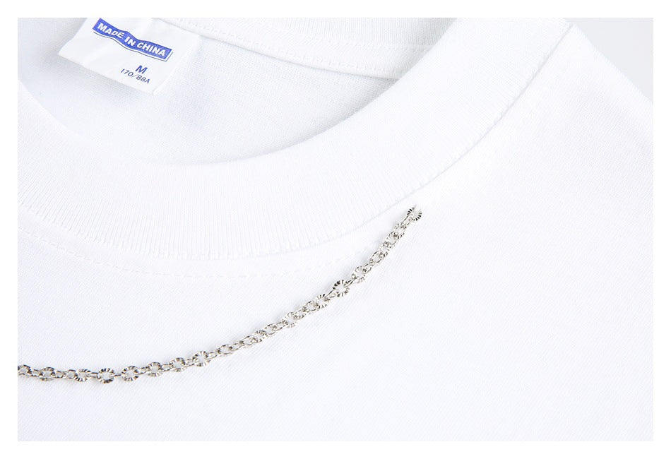 Close-up of a white shirt neckline with a silver chain embellishment and a visible English size and origin label.