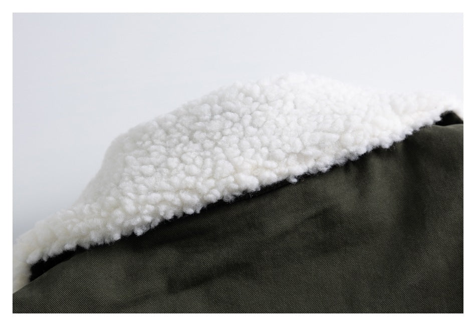 Close-up of white fluffy lining against dark olive garment fabric.