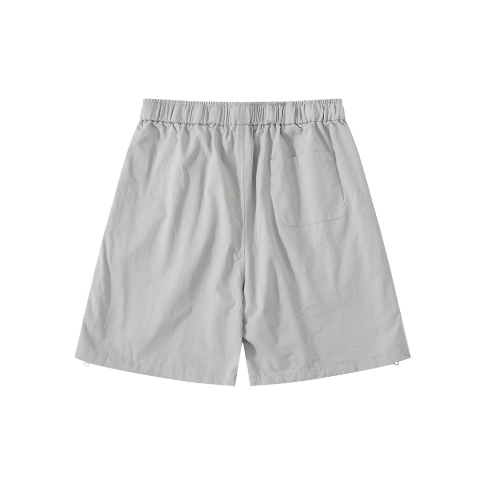 Back view of light gray shorts with elastic waistband, one patch pocket and side hem zipper pulls