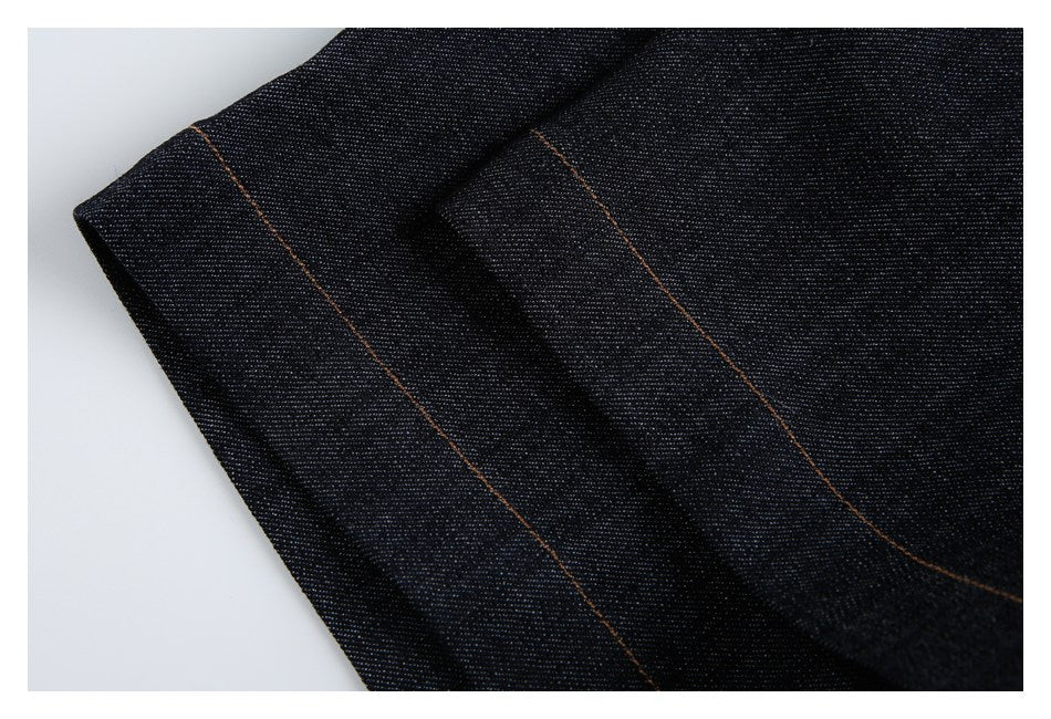 Close-up of a folded edge in dark denim with parallel brown stitching.