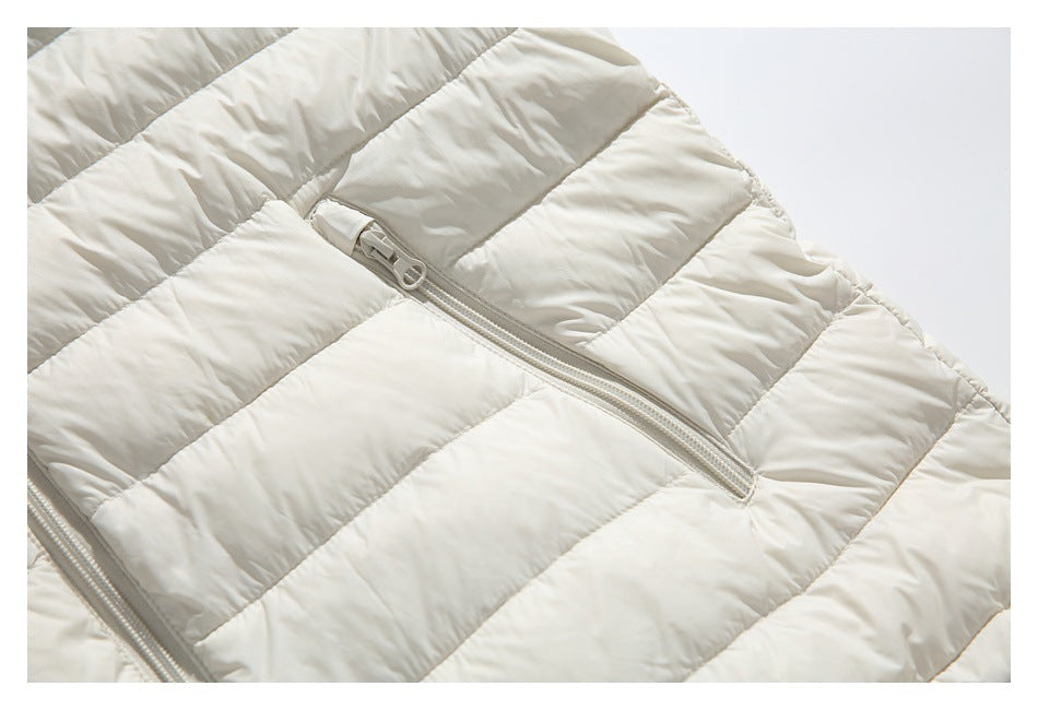 Close-up of a diagonal zipper pocket on the horizontally quilted ivory jacket.