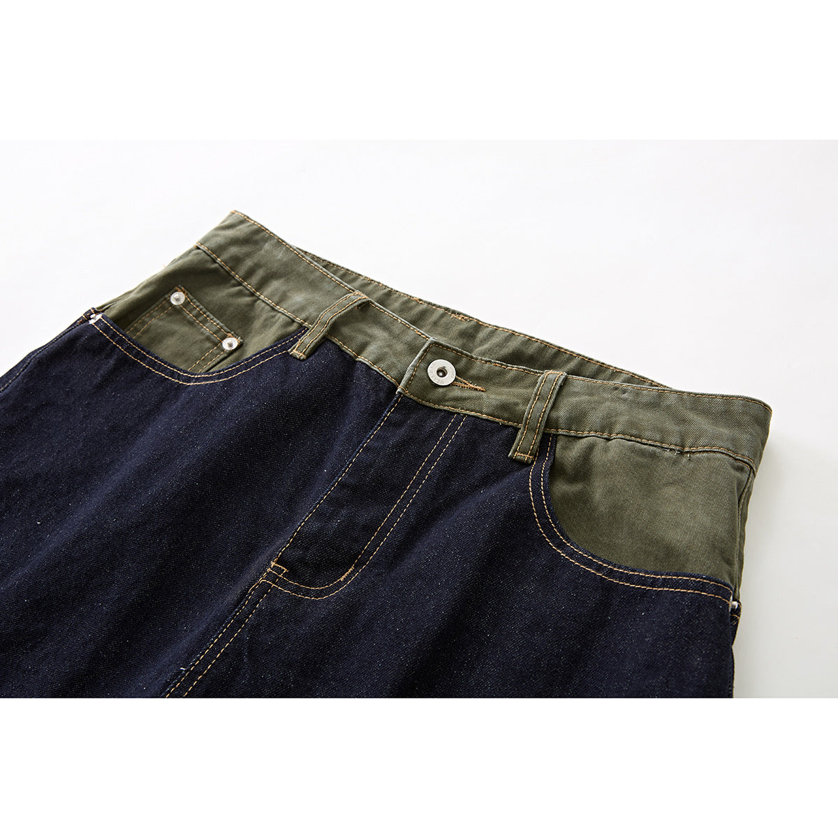 Close-up of dark indigo denim shorts with an olive-green waistband, front pockets, metal button and contrast stitching.