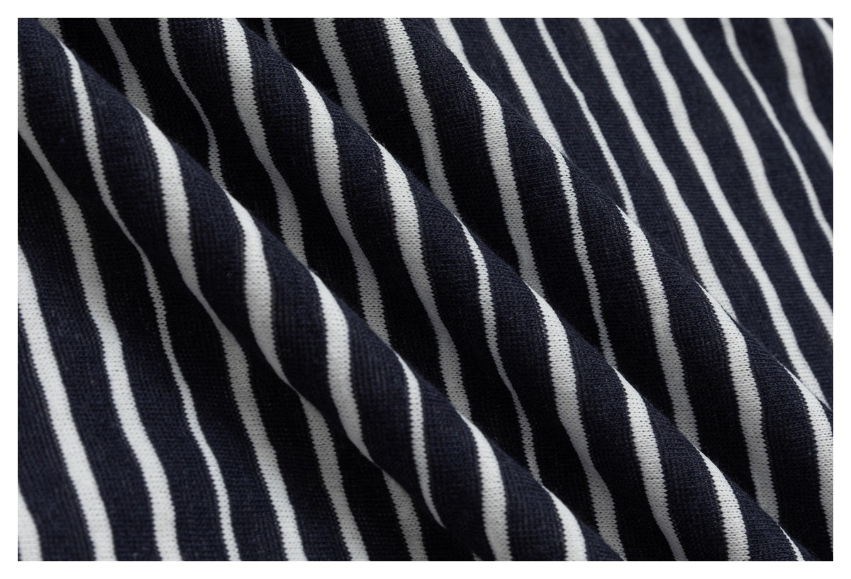 Macro view of navy fabric with narrow white stripes draped in folds.