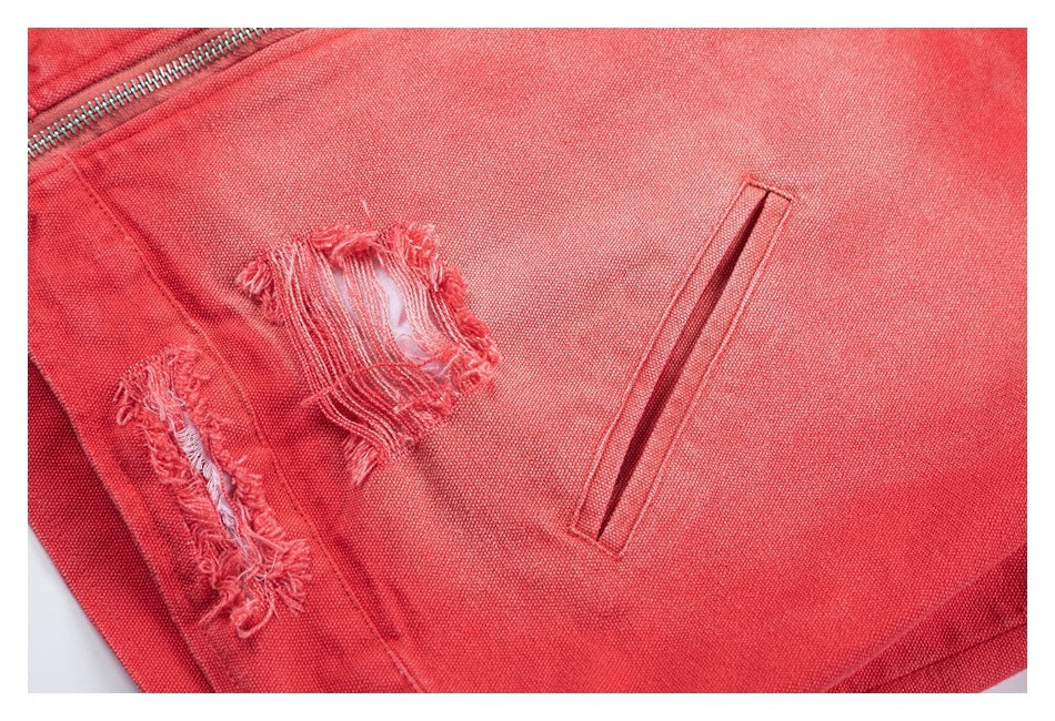 Close-up of a coral-red jacket with distressed fabric patches and a narrow welt pocket.