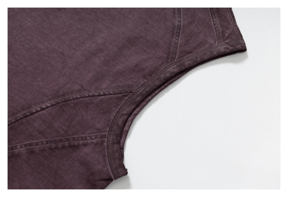 Close-up of the curved armhole and stitched panel seams on a dark plum shirt.