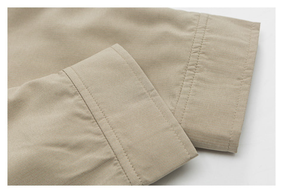 Close-up of beige fabric showing two overlapping stitched hems with parallel edge stitching.