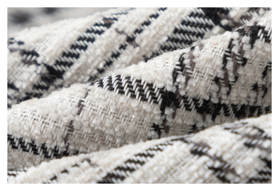 Macro view of the raised cream and black plaid fabric weave.