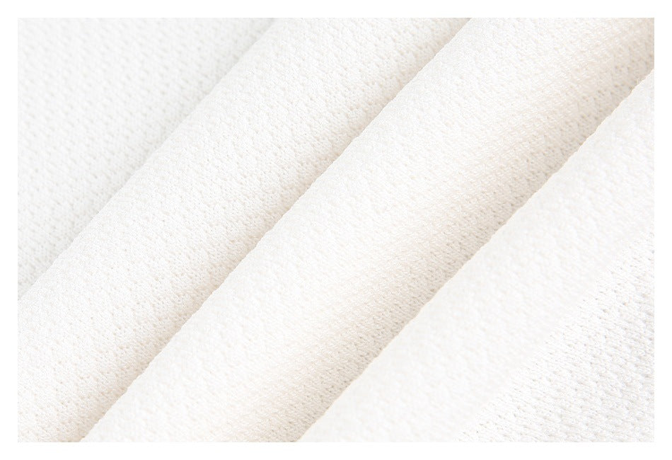 Close-up of white knit fabric folded into diagonal layers.
