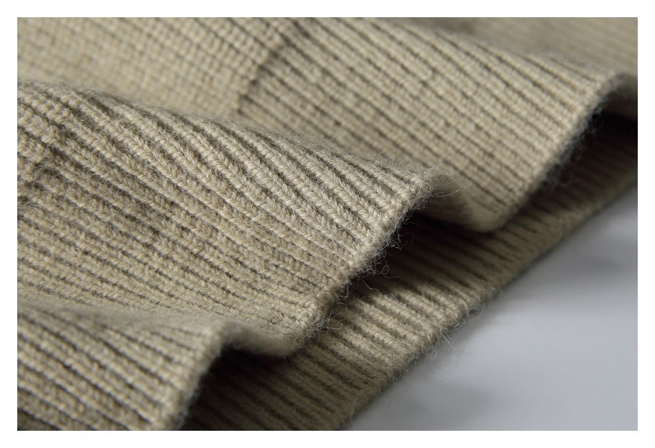 Close-up of a beige rib-knit garment edge folded over, showing the textured stitching.