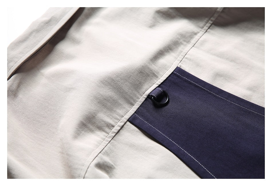 Detailed view of beige fabric and stitching beside a navy panel with a black button.