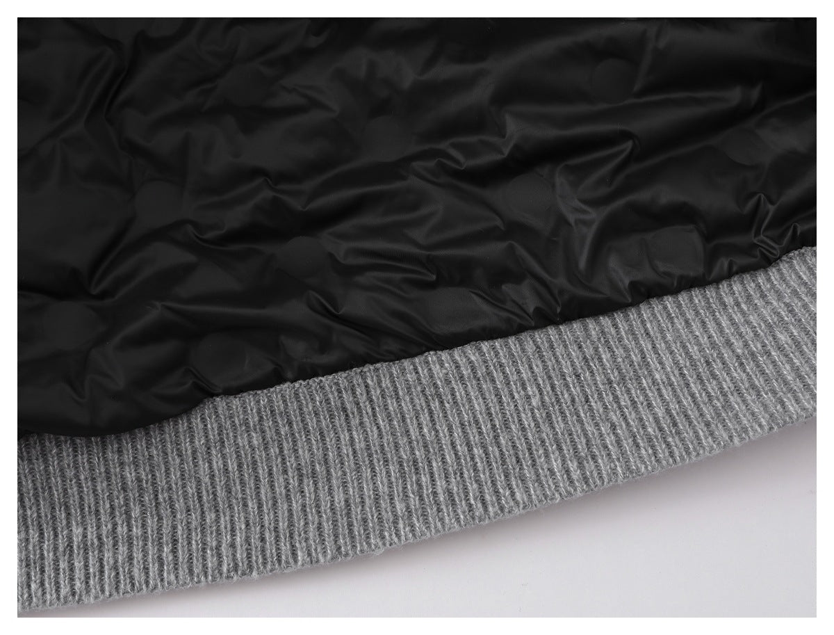 Close-up of a gray ribbed knit hem beside black lining.
